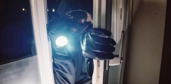 Masked,Burglar,Entering,Amd,Breaking,Into,A,House,Window,With Dunkle Jahreszeit hat begonnen: Erhöhtes Einbruchrisiko - Polizei intensiviert Maßnahmen und gibt Tipps zum Schutz