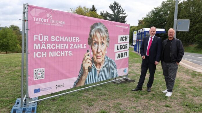 Bildunterschrift: Klare Botschaft: Bürgermeister Christian Litzinger und Ordnungsamtsleiter Bastian Metzler (von links) mit dem Wanderplakat, das Seniorinnen und Senioren vor Schockanrufen warnen soll. Foto: Stadt Gelnhausen